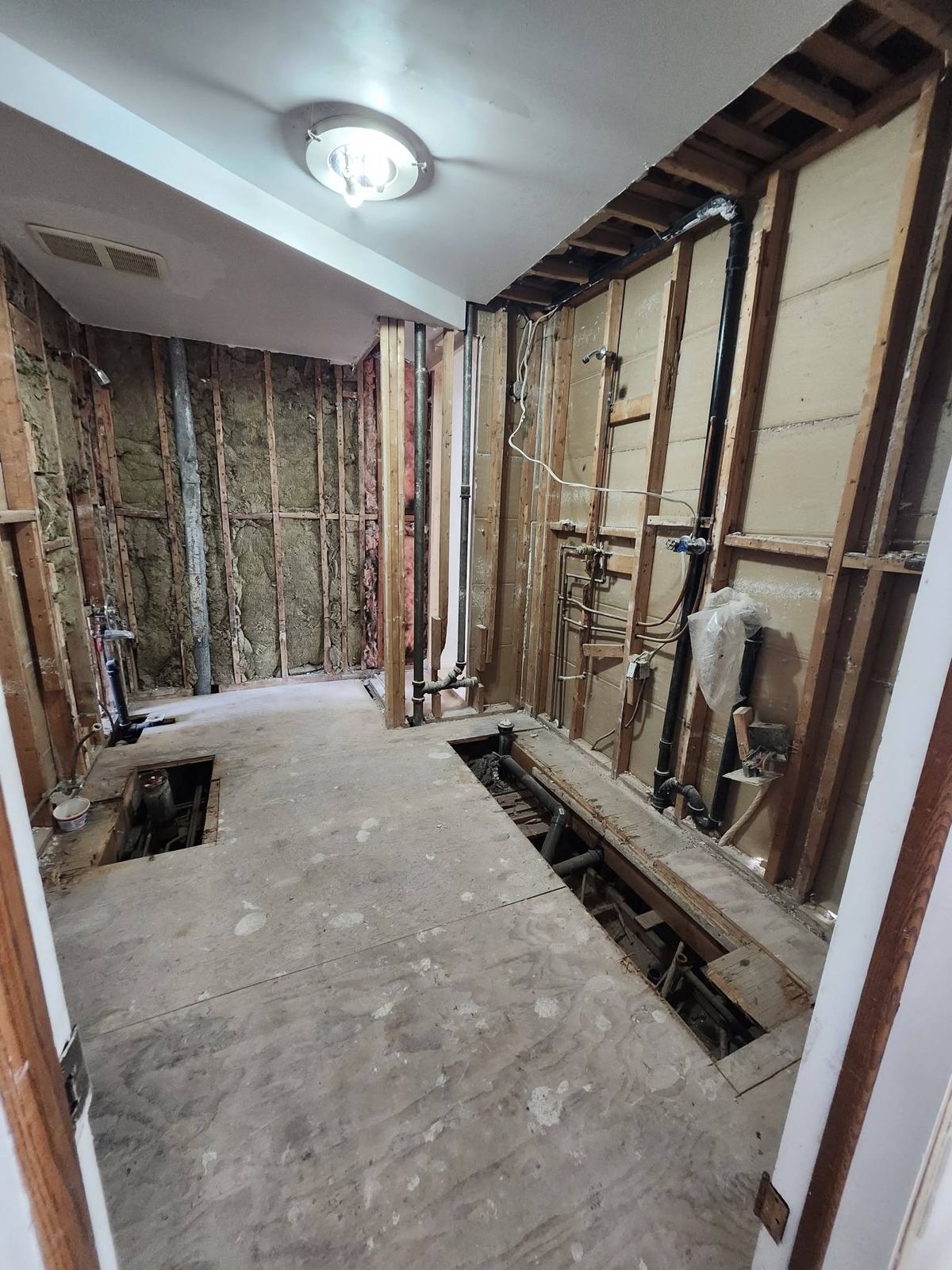 Salle de bain démolie jusqu'aux montants, plomberie visible