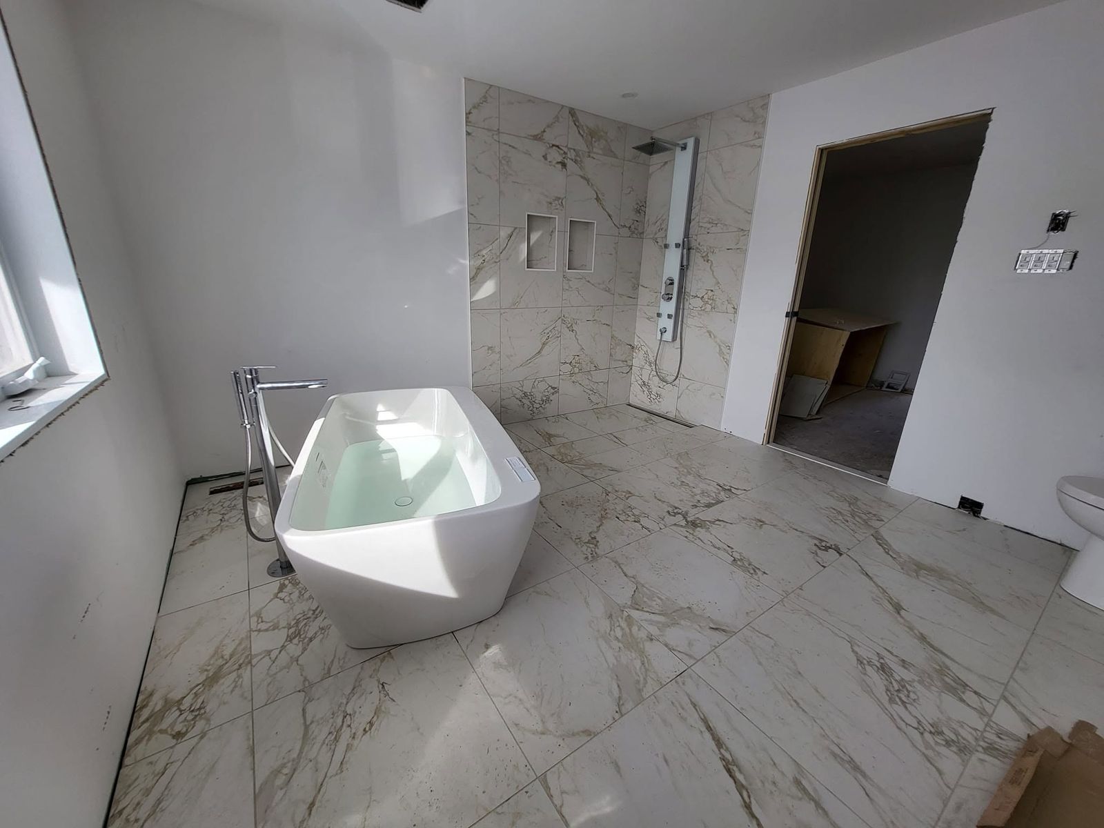 Salle de bain avec céramique effet marbre et bain autoportant